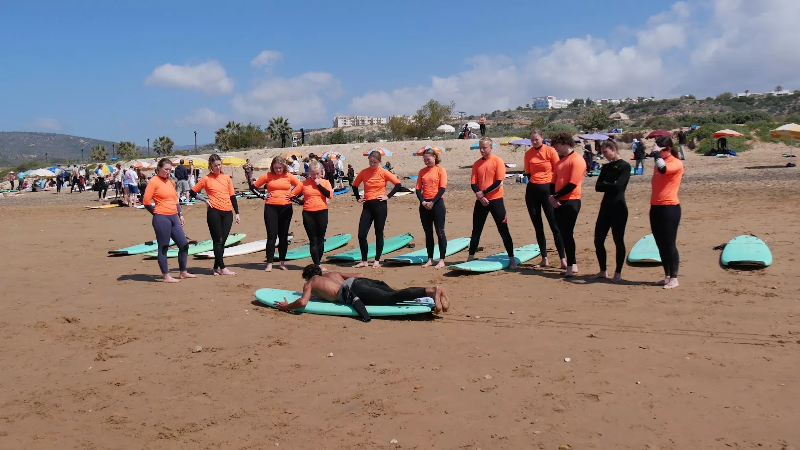 Entrenador de surf explicando seguridad en la playa y nociones básicas de pop-up en Taghazout